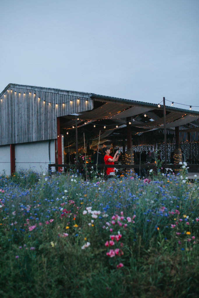Wild floral meadow adding a sense of summer to the cow shed wedding.