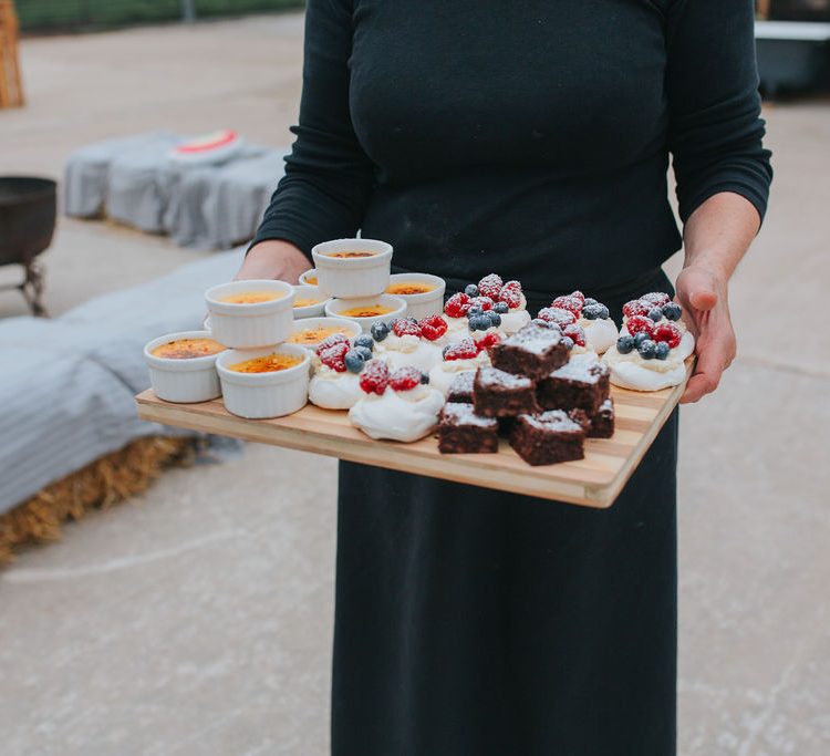 A board of delicious desserts, brownies, crème brulees and Eton messes, making their way into the cow shed for guests to eat.
