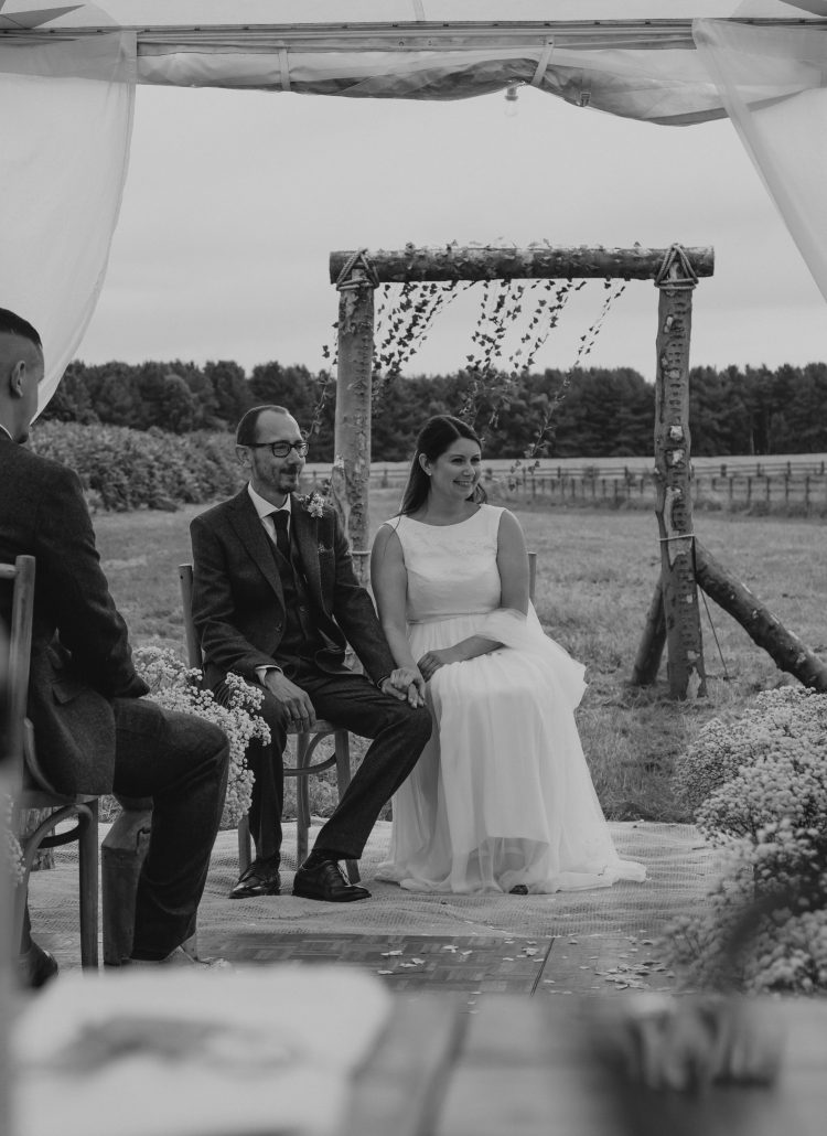 D&J sit during their bespoke celebrant ceremony in a marquee in their back garden.