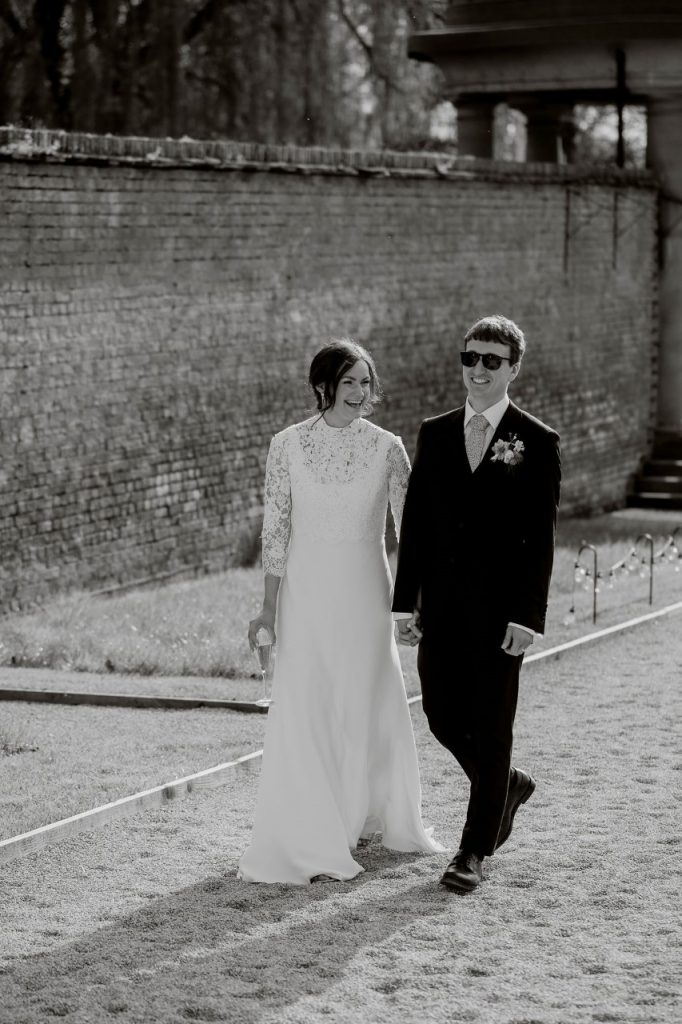 Ellie & James walk hand in hand through the grounds of the Walled Garden at Helperby. 