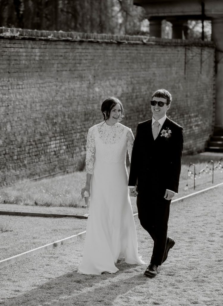 Ellie & James walk hand in hand through the grounds of the Walled Garden at Helperby.
